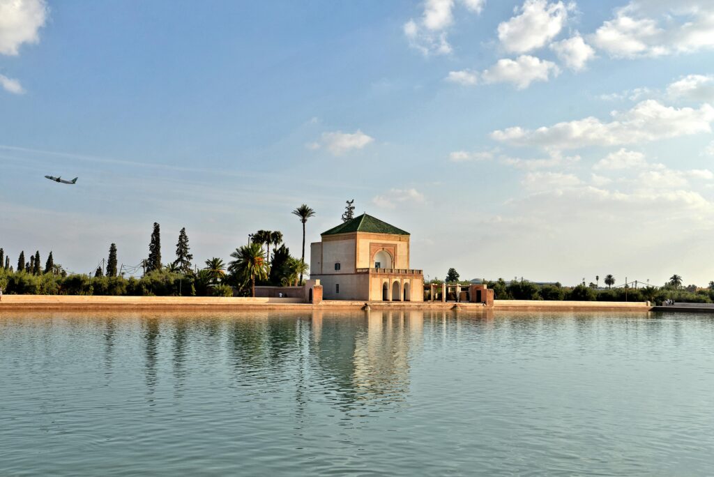 Scenic view of Menara Gardens pavilion reflecting in a tranquil lake in Marrakech, Morocco.